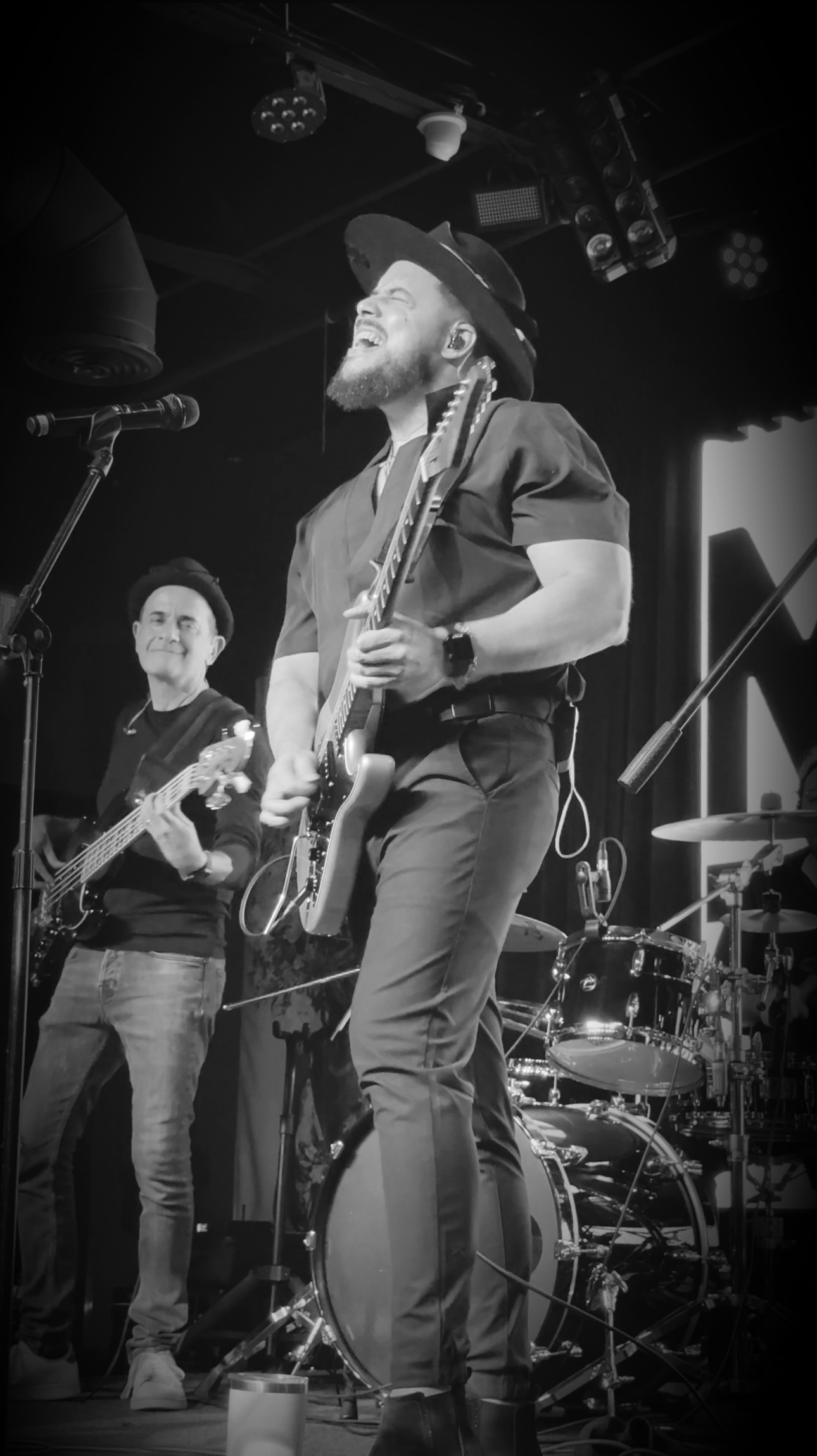 Will Plus singing and playing electric guitar with his live band